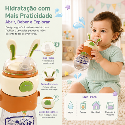 Criança pequena sentada no chão a segurar e a beber pela garrafa infantil ergonómica com bico de silicone macio e tampa de coelho.