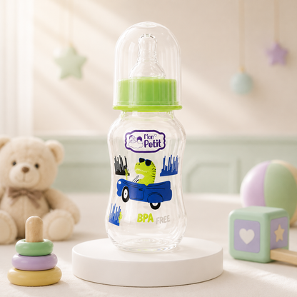 Biberão infantil Mon Petit de 250ml colocado num palanque redondo num quarto de bebé com brinquedos de madeira decorativos.