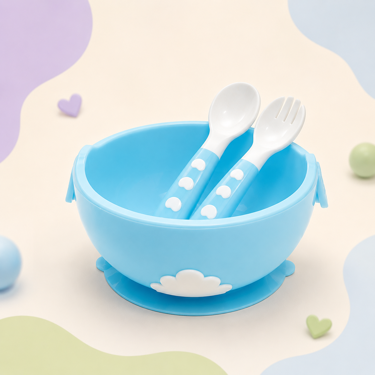 Conjunto de refeição para bebé Mon Petit composto por prato taça azul com ventosa antiderrapante e talheres ergonómicos em tons de azul e branco, exposto num cenário decorativo de tons pastel com corações.
