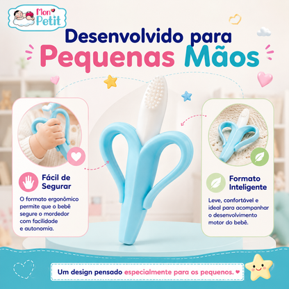 Bebé a segurar mordedor ergonómico em forma de banana desenvolvido para pequenas mãos.