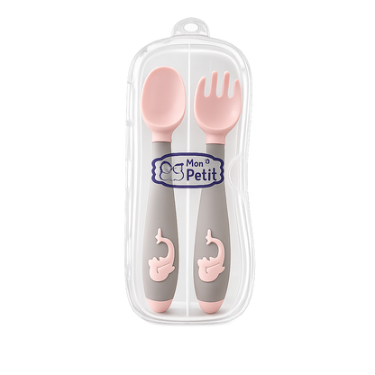 Conjunto de colher e garfo de aprendizagem para bebé em silicone rosa e cinzento, guardados dentro de um estojo protetor transparente com o logótipo Mon Petit.
