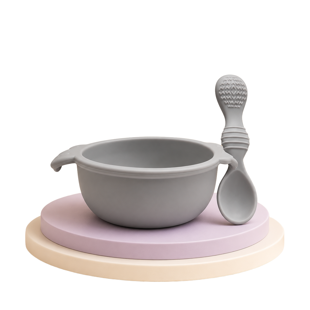 Conjunto de tigela e colher de silicone cinzenta para bebé sobre suporte decorativo.